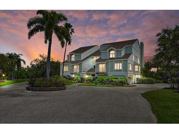 Stunning townhome showcasing lush landscaping, charming balconies, and a serene coastal ambiance at twilight at 123 Tidy Island Blvd, Bradenton, FL 34210