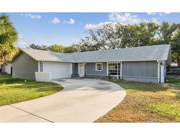 Ranch style home with a paved driveway and mature trees at 7802 Scruboak Ct, Hudson, FL 34667