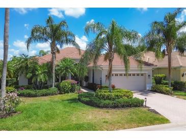 Luxury home with a tile roof, lush landscaping, and a paved driveway at 13853 Siena Loop, Lakewood Ranch, FL 34202