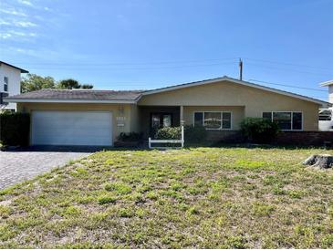 Charming one-story home featuring an attached garage and a well-maintained front yard at 6613 Blue Heron S Dr, St Petersburg, FL 33707