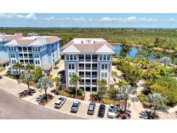 Aerial view of waterfront community building with parking at 395 Aruba Cir # 102, Bradenton, FL 34209