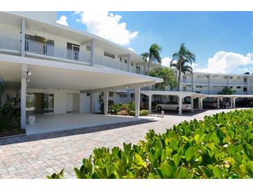 Modern building with covered parking and lush landscaping at 100 Sands Point Rd # 324, Longboat Key, FL 34228