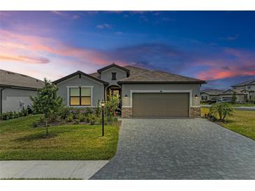 One-story home with gray exterior and paver driveway at 15739 Barefoot Beach Dr, Bradenton, FL 34211