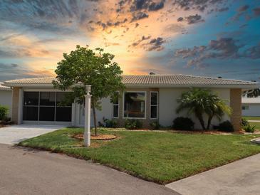 Single story home with landscaped yard and sunset view at 334 Circlewood Dr # E3-2, Venice, FL 34293