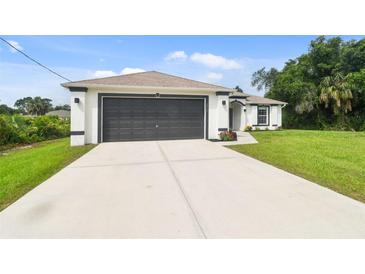 Charming single-story home showcasing a well-manicured lawn and a spacious two-car garage at 2511 Stagnaro Rd, North Port, FL 34287