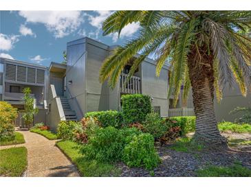 Condo building with lush landscaping and walkway at 207 Woodland Dr # 207, Osprey, FL 34229