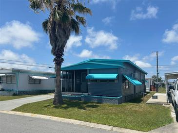 Charming single-story home with a cozy screened-in porch and a well-maintained lawn, shaded by a mature palm tree at 611 51St Avenue W Plz, Bradenton, FL 34207