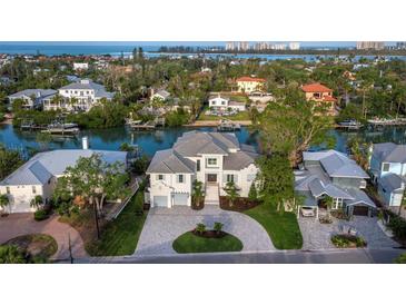 Beautiful aerial view of waterfront home with circular driveway and lush landscaping at 3550 Flamingo Ave, Sarasota, FL 34242