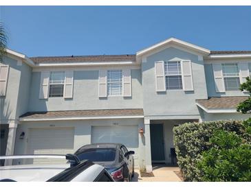 Two-story light blue townhome with two-car garage and lush landscaping at 14812 Skip Jack Loop, Lakewood Ranch, FL 34202