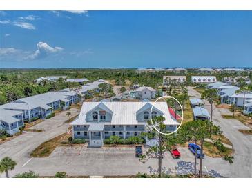 Aerial view of a condo community with a pool and tennis courts at 6800 Placida Rd # 281, Englewood, FL 34224