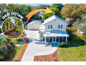 Charming home with guest cottage, featuring a metal roof and well-maintained landscaping at 1810 28Th W St, Bradenton, FL 34205