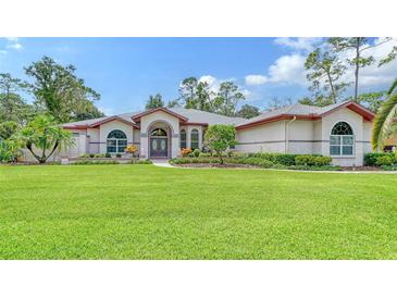 Stunning home showcasing a well-manicured lawn and beautiful landscaping at 7430 Weeping Willow Dr, Sarasota, FL 34241