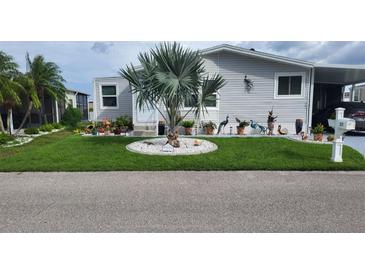 Single-wide manufactured home with well-manicured lawn at 577 Portside Dr, North Port, FL 34287