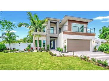 Stunning two-story modern home featuring clean lines, balcony, lush landscaping, and an attached two-car garage at 1805 Goldenrod St, Sarasota, FL 34239