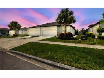 Two-car garage, light-colored exterior, landscaping at 8549 Whispering St, Sarasota, FL 34240