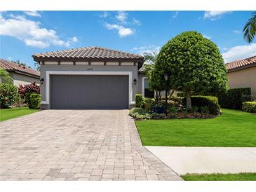 House exterior featuring a gray garage door and manicured lawn at 13202 Torresina Ter, Bradenton, FL 34211