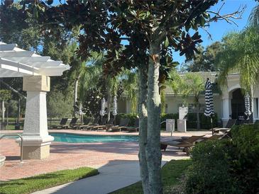 Relaxing community pool with lounge chairs and a pergola at 5146 Northridge Rd # 201, Sarasota, FL 34238