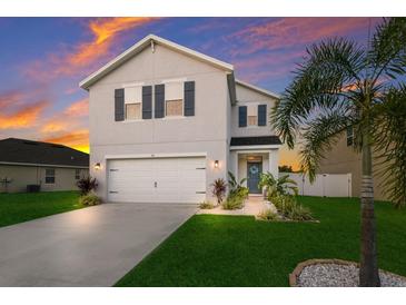Two-story house with gray siding, white garage door, and landscaping at 335 Gris Sky Ln, Bradenton, FL 34212