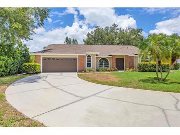 Charming single-story home with a large driveway and a well-manicured lawn with mature trees and landscaping at 4709 Foy Pl, Sarasota, FL 34243