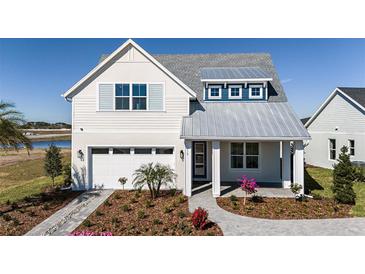 Two-story home with metal roof, shutters, and landscaped yard at 725 Anegada Ln, Sarasota, FL 34234