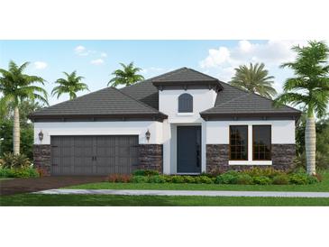 Charming, modern home exterior with gray roof, stone accents, and lush tropical landscaping at 429 Alberata Way, Nokomis, FL 34275