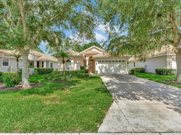 Charming single-story home with a well-manicured lawn and mature trees providing shade and curb appeal at 4145 Reflections Pkwy, Sarasota, FL 34233