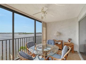 Glass-top table and chairs on a lanai overlooking the water at 8911 Midnight Pass Rd # 410, Sarasota, FL 34242
