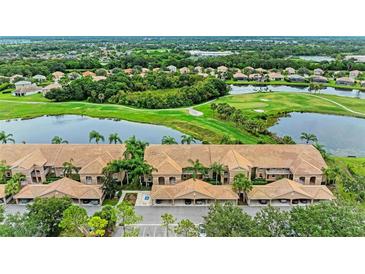 Stunning aerial view of condo community with golf course, lake, and lush landscaping at 1003 Fairwaycove Ln # 205, Bradenton, FL 34212