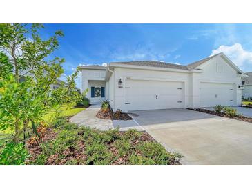Two-car garage and walkway to the front entrance of a house at 14631 Barefoot Ln, Parrish, FL 34219