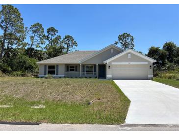 Charming single-story home featuring a two-car garage, a welcoming front porch, and a well-maintained lawn at 4012 Oscar Ter, North Port, FL 34286