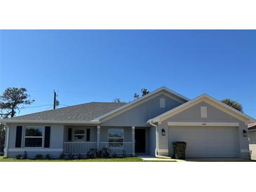 Charming single-story home featuring a well-manicured lawn, gray exterior, and attached two-car garage at 4860 Florida Rd, Venice, FL 34293