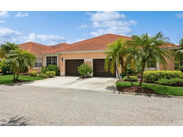 Charming home features a tile roof, two-car garage and beautiful landscaping at 5635 Spanish Point Ct, Palmetto, FL 34221