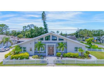Modern home with gray brick exterior, white fence, and landscaped yard at 3502 Bahia Vista St, Sarasota, FL 34239