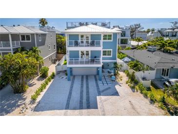 Two-story house with light blue exterior, driveway, and partial ocean view at 2102 Avenue B, Bradenton Beach, FL 34217