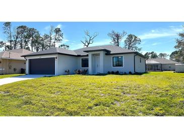 Single-story home with dark gray garage door and green lawn at 2017 Lovoy Ct, North Port, FL 34288