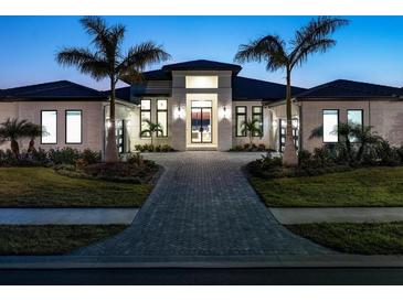 Luxury home with modern design, a paved driveway, and lush landscaping at 1158 Blue Shell Loop, Sarasota, FL 34240