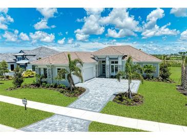 Luxury home exterior with stone accents and palm trees at 11414 Brightly Dr, Venice, FL 34293