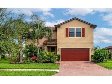 Two-story house with red garage door and landscaping at 2352 Marton Oak Blvd, North Port, FL 34289