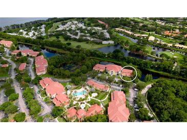 Beautiful aerial view of community with pool, green spaces, and waterway access at 4751 Travini Circle # 4-116, Sarasota, FL 34235