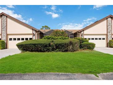 Tan siding duplex with two-car garages and lush landscaping at 5607 Avista Dr, Sarasota, FL 34243