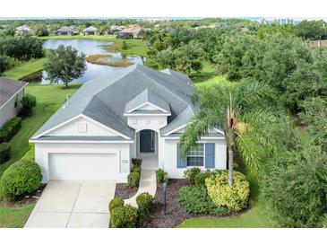 Beautiful home featuring a well-manicured lawn and a lovely view of a tranquil lake in the background at 11406 Belvedere Ter, Lakewood Ranch, FL 34211