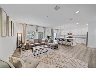 Open-concept living room with a modern kitchen and a large sectional sofa at 1807 Robinhood St, Sarasota, FL 34231