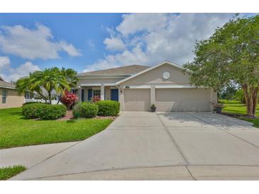 Charming single-story home featuring a manicured lawn, mature trees, and a spacious three-car garage at 11622 Summit Rock Ct, Parrish, FL 34219