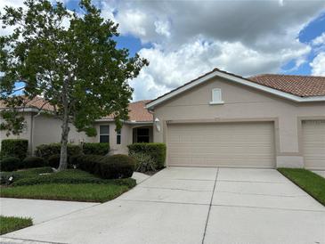 Tan, two-car garage villa with lush landscaping at 4271 Cascade Falls Dr, Sarasota, FL 34243