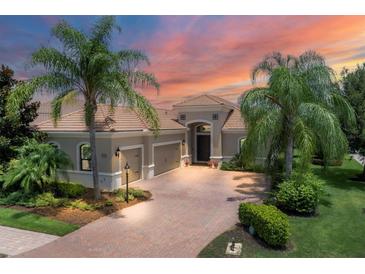 Luxury home exterior at sunset, featuring a tile roof and palm trees at 14215 Kinglet Ter, Lakewood Ranch, FL 34202