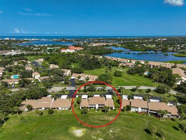 Aerial view of condo community near the water with tennis courts and pool at 684 Bird Bay W Dr # 132, Venice, FL 34285