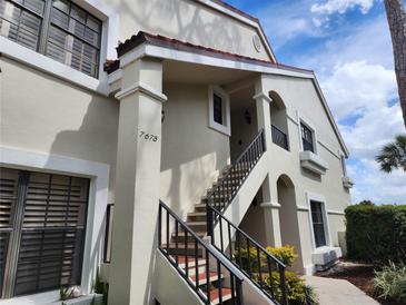 Inviting condo featuring stucco facade, red tile roof and beautiful stairway entrance at 7673 Fairway Woods Dr # 706, Sarasota, FL 34238