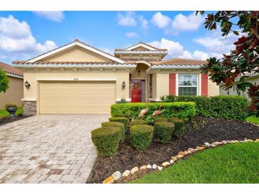 One-story home with landscaped yard and red door at 8214 Las Lilias Ct, Sarasota, FL 34243