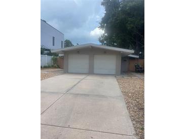 Two-car garage and light-colored house exterior with landscaping at 1928 9Th St, Sarasota, FL 34236