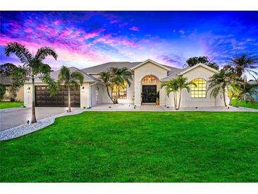 Single-story home with a landscaped yard at sunset at 158 Allworthy St, Port Charlotte, FL 33954